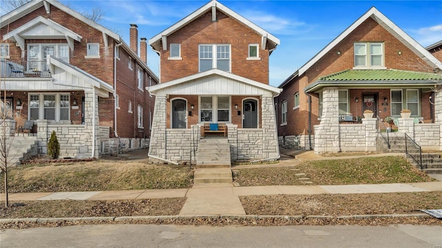 view of front of house featuring a porch, stone siding, and brick siding