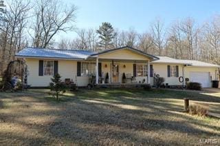 ranch-style home with a garage, a porch, and a front yard