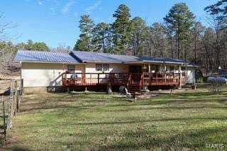back of property with a lawn and a deck