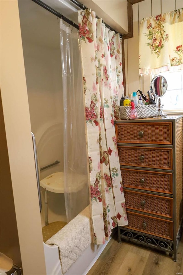 bathroom with shower / bath combination with curtain and wood-type flooring
