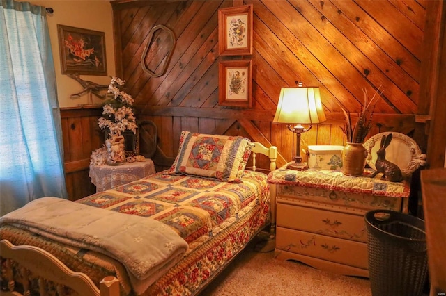 bedroom with carpet floors and wood walls