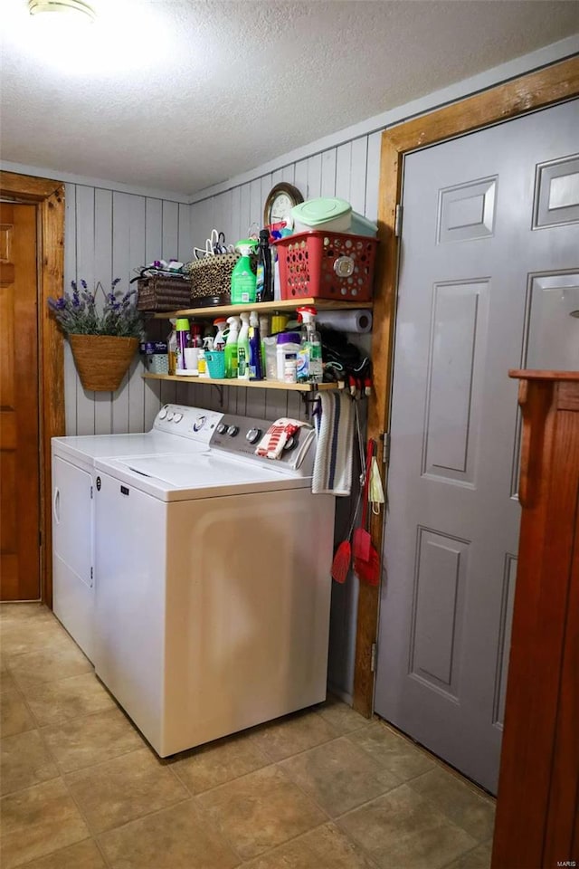 clothes washing area featuring a textured ceiling and washing machine and clothes dryer