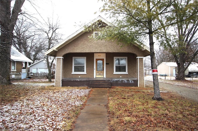 bungalow-style house with a porch and stucco siding