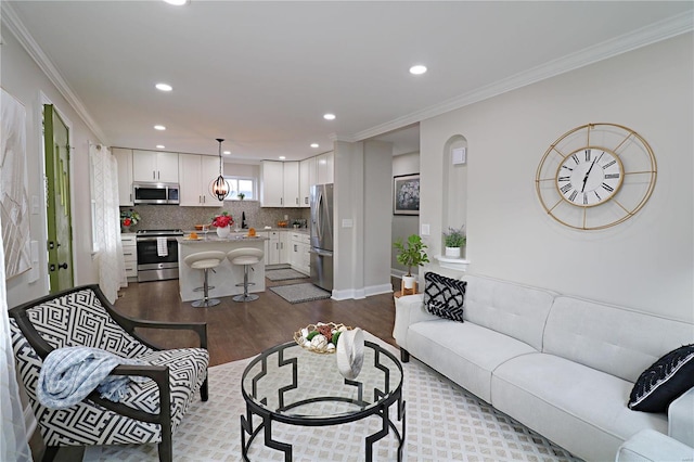 living room with dark wood-style floors, recessed lighting, baseboards, and ornamental molding