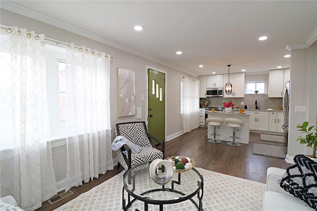 living room featuring visible vents, baseboards, dark wood finished floors, recessed lighting, and crown molding