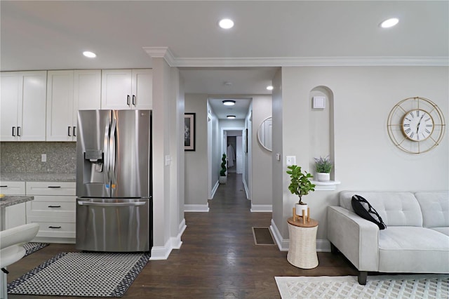 kitchen with stainless steel refrigerator with ice dispenser, backsplash, recessed lighting, white cabinets, and dark wood-style flooring