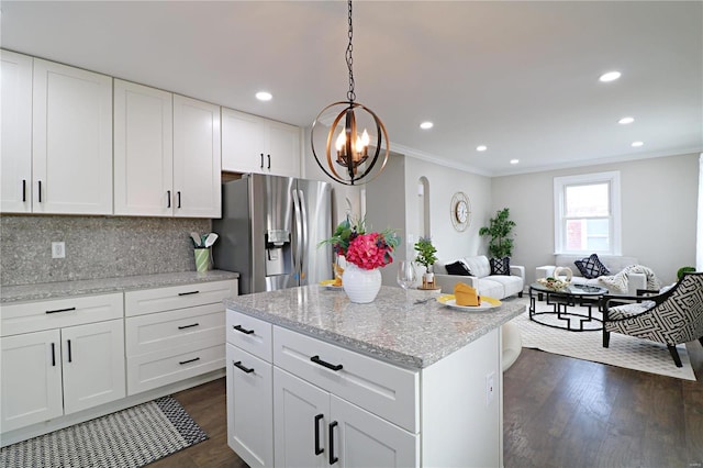 kitchen featuring ornamental molding, dark wood-type flooring, stainless steel fridge, tasteful backsplash, and open floor plan