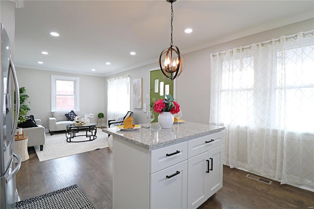 kitchen with crown molding, stainless steel refrigerator with ice dispenser, dark wood-style floors, and visible vents