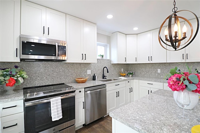 kitchen with dark wood-type flooring, a sink, backsplash, white cabinetry, and appliances with stainless steel finishes