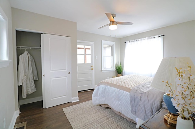 bedroom with a closet, multiple windows, baseboards, and wood finished floors