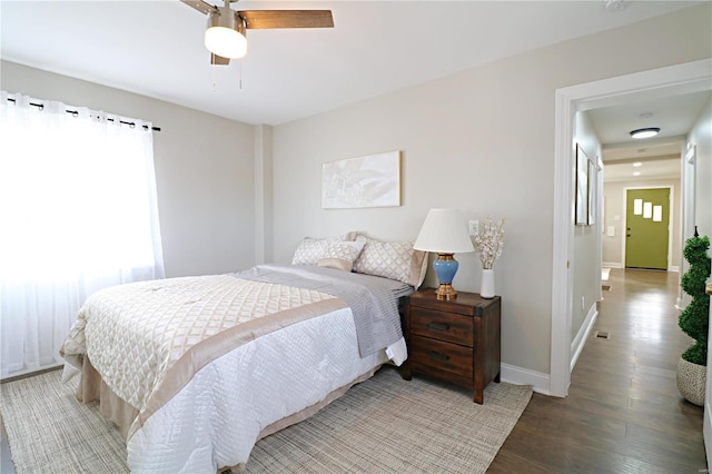 bedroom featuring a ceiling fan, wood finished floors, and baseboards