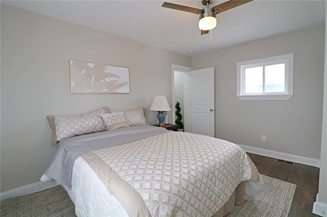 bedroom with visible vents, baseboards, dark wood-type flooring, and a ceiling fan