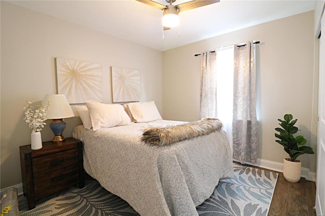 bedroom with a ceiling fan, baseboards, and wood finished floors