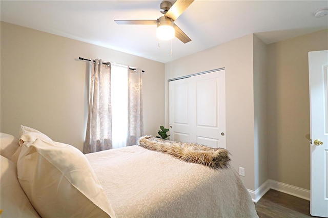 bedroom featuring a closet, dark wood finished floors, a ceiling fan, and baseboards