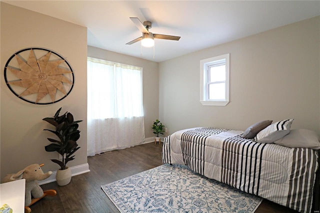 bedroom with multiple windows, a ceiling fan, baseboards, and wood finished floors