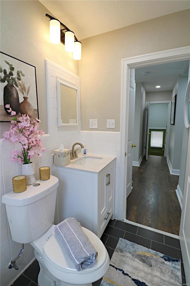 bathroom with tile patterned floors, wainscoting, tile walls, and vanity