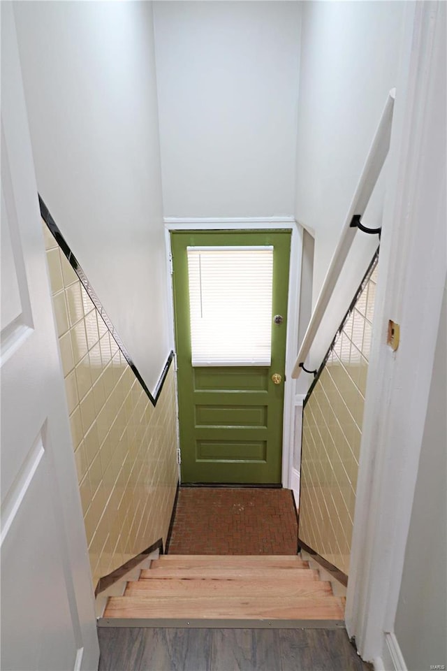 entryway featuring stairway, tile walls, and wood finished floors