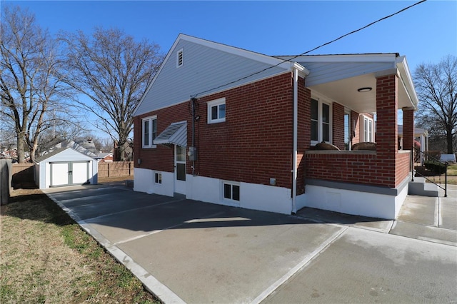 view of side of property featuring brick siding, an outdoor structure, a storage shed, and fence