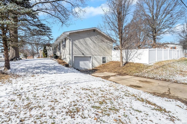 snow covered property featuring a garage