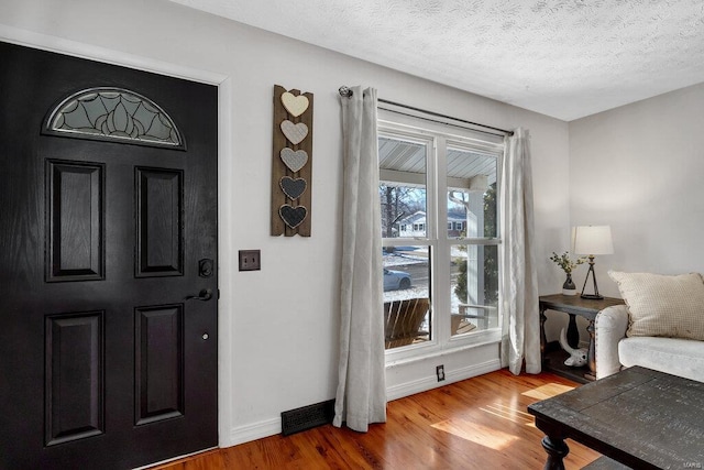 foyer entrance featuring wood-type flooring and a textured ceiling