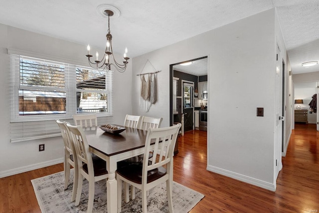 dining room with an inviting chandelier, dark hardwood / wood-style floors, and a textured ceiling