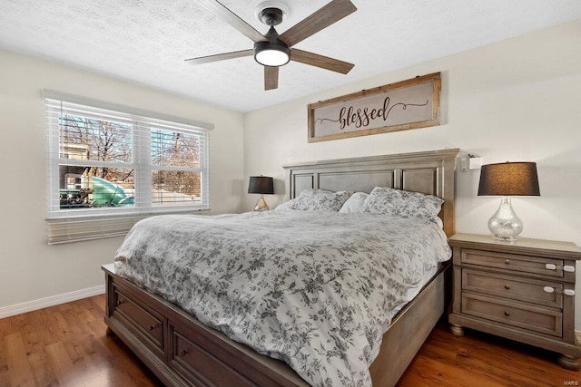 bedroom featuring dark wood-type flooring, a textured ceiling, and ceiling fan