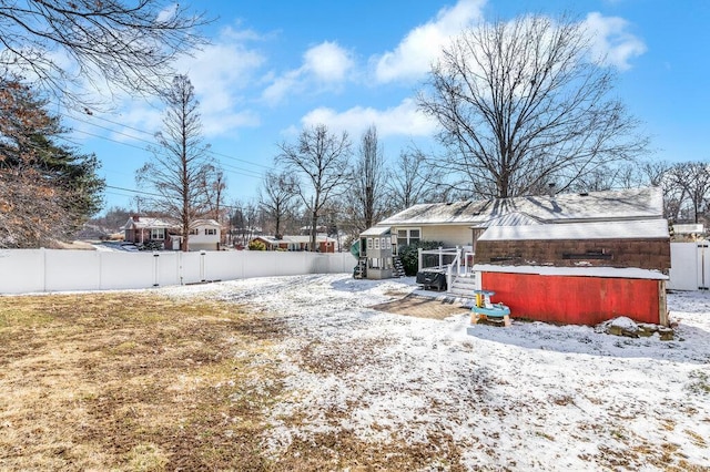 yard covered in snow with a wooden deck