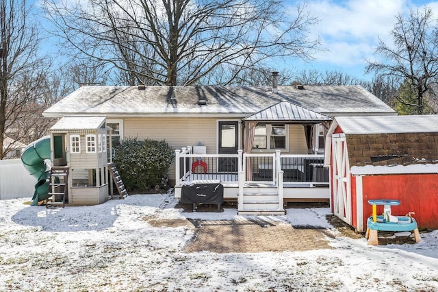 view of front of house with a playground and a deck