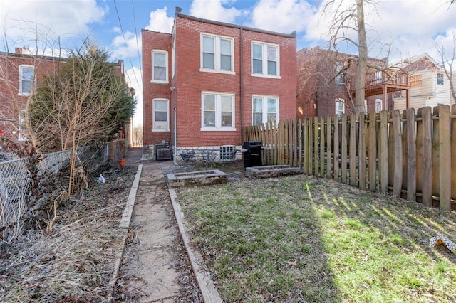 back of property featuring a fenced backyard and brick siding