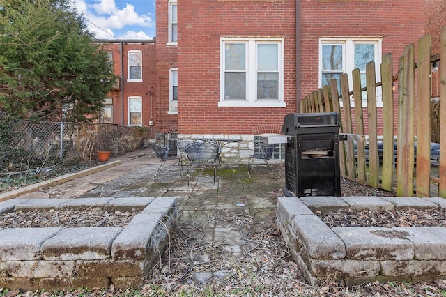 exterior space with a patio, brick siding, and fence