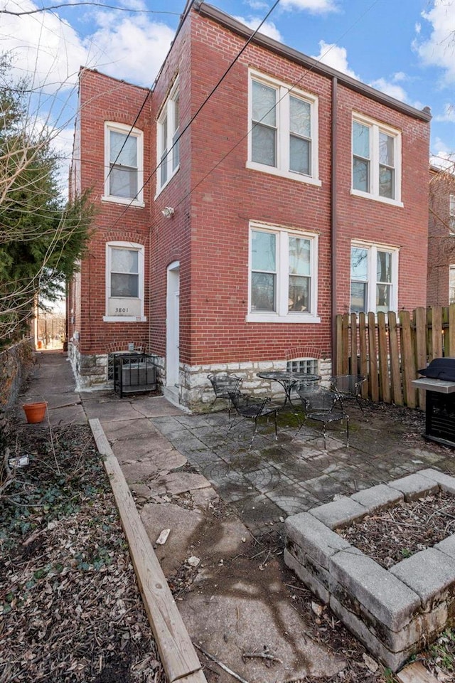 exterior space with brick siding and fence