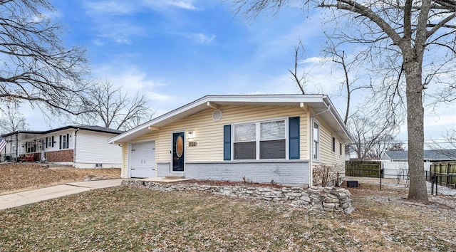 bungalow-style home featuring driveway, brick siding, an attached garage, and fence