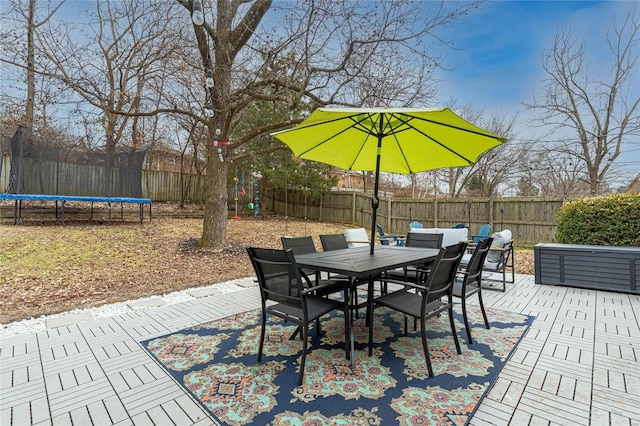 wooden deck with a trampoline and a patio