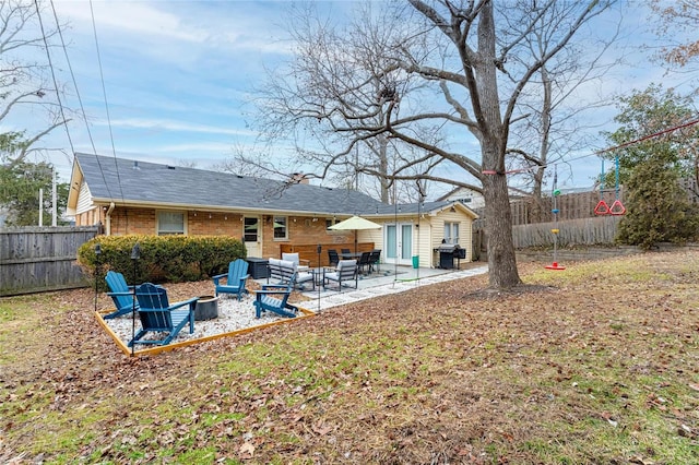 rear view of property with a patio area and a fire pit