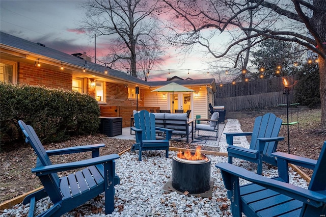 patio terrace at dusk featuring an outdoor living space with a fire pit