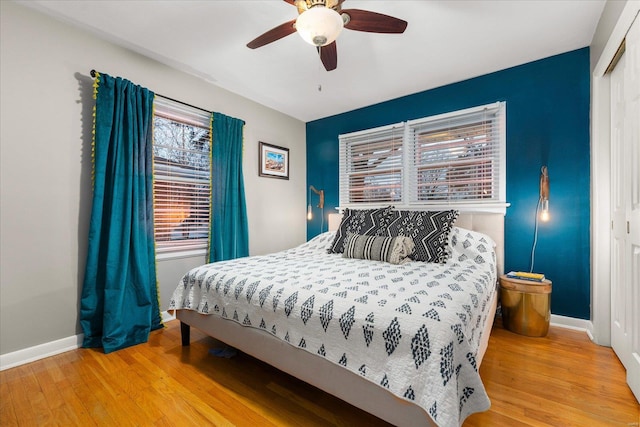 bedroom with ceiling fan, a closet, and light hardwood / wood-style floors