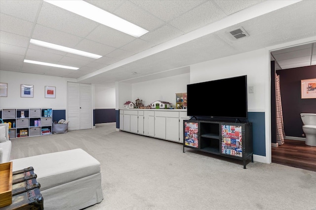 carpeted living room with a paneled ceiling