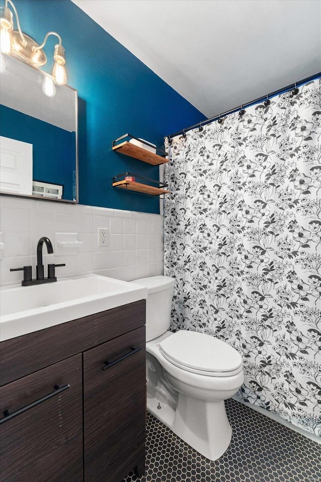 bathroom featuring tile patterned floors, toilet, tile walls, and vanity