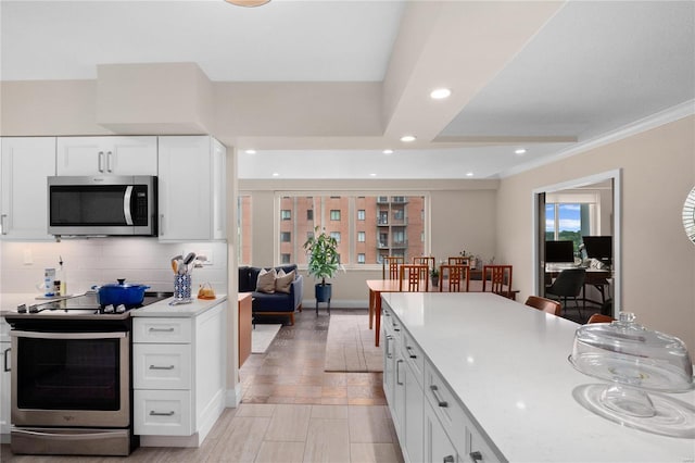 kitchen with recessed lighting, white cabinetry, light countertops, appliances with stainless steel finishes, and tasteful backsplash