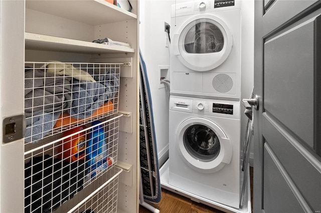 washroom featuring stacked washer / dryer and wood finished floors