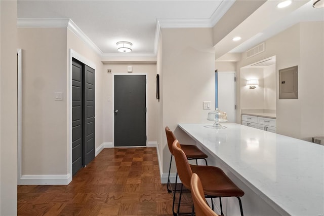 interior space with baseboards, electric panel, ornamental molding, and visible vents