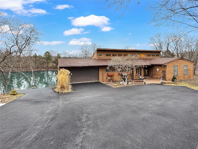 view of front of home with a garage and a water view