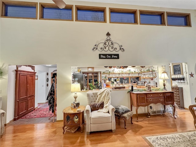 sitting room with a towering ceiling and light hardwood / wood-style floors