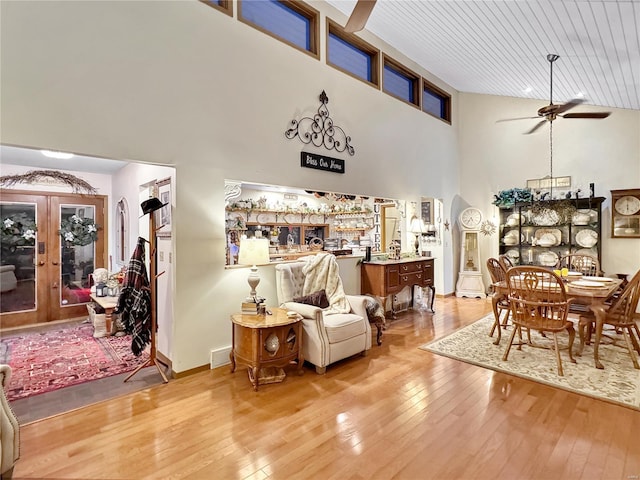 interior space featuring light hardwood / wood-style flooring, a high ceiling, ceiling fan, wood ceiling, and french doors