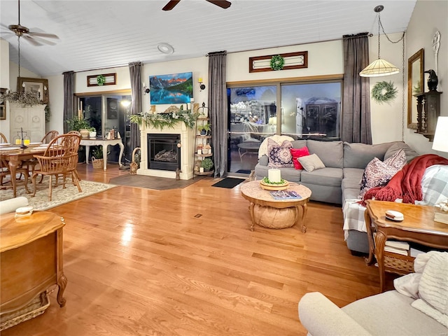 living room featuring wood-type flooring, vaulted ceiling, and ceiling fan