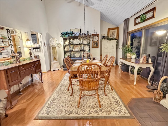 dining room with high vaulted ceiling, wood ceiling, and light wood-type flooring