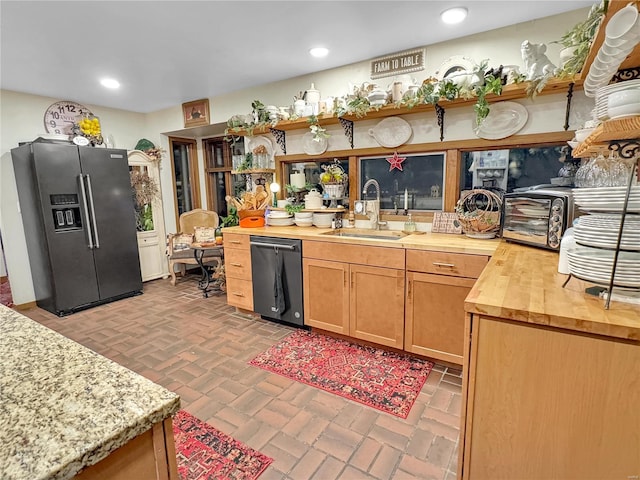 kitchen featuring high end refrigerator, dishwashing machine, sink, and butcher block countertops