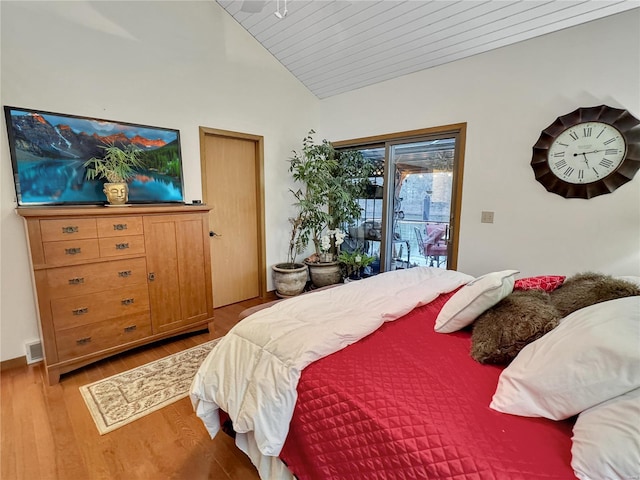 bedroom with lofted ceiling, access to exterior, and light hardwood / wood-style flooring