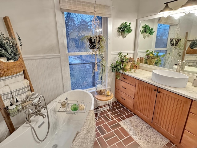 bathroom with vanity, a chandelier, and a washtub