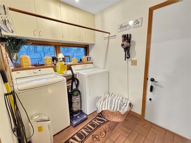 washroom featuring washer and clothes dryer and cabinets